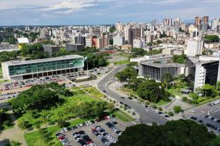 Imagem aérea do centro Cívicio, em Curitiba. O Palácio Iguaçu aparece em destaque no canto superior esquerdo. À direita, o prédio da Assembleia Legislativa do Paraná. Ao fundo, prédios compõem a cena