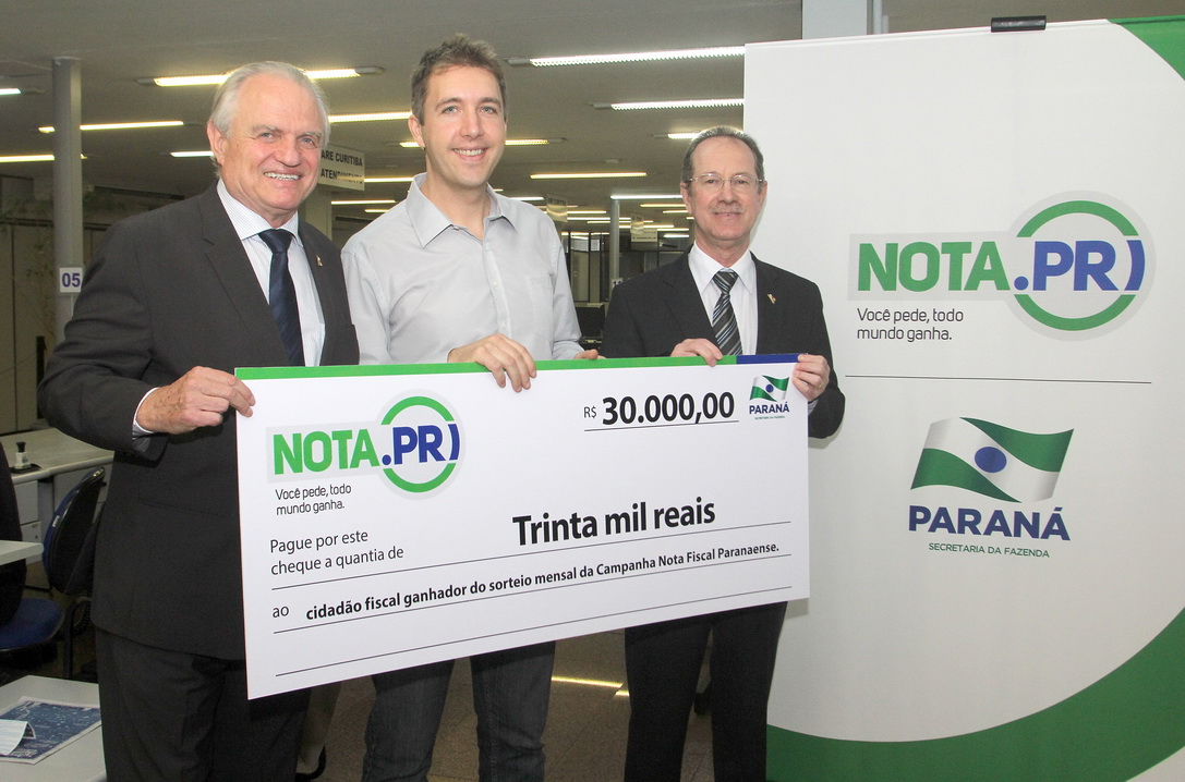 O psicólogo curitibano Marcio Simioni recebeu nesta quarta-feira (18) um cheque simbólico do primeiro prêmio mensal da campanha Nota Fiscal Paranaense, no valor de R$ 30 mil. Ele foi contemplado no sorteio realizado no dia 28 de maio. Outra premiada foi a professora Rosane Bihre Mattes, da rede municipal de ensino de Curitiba, que recebeu um cheque simbólico de R$ 20 mil, referente a um prêmio semanal acumulado.