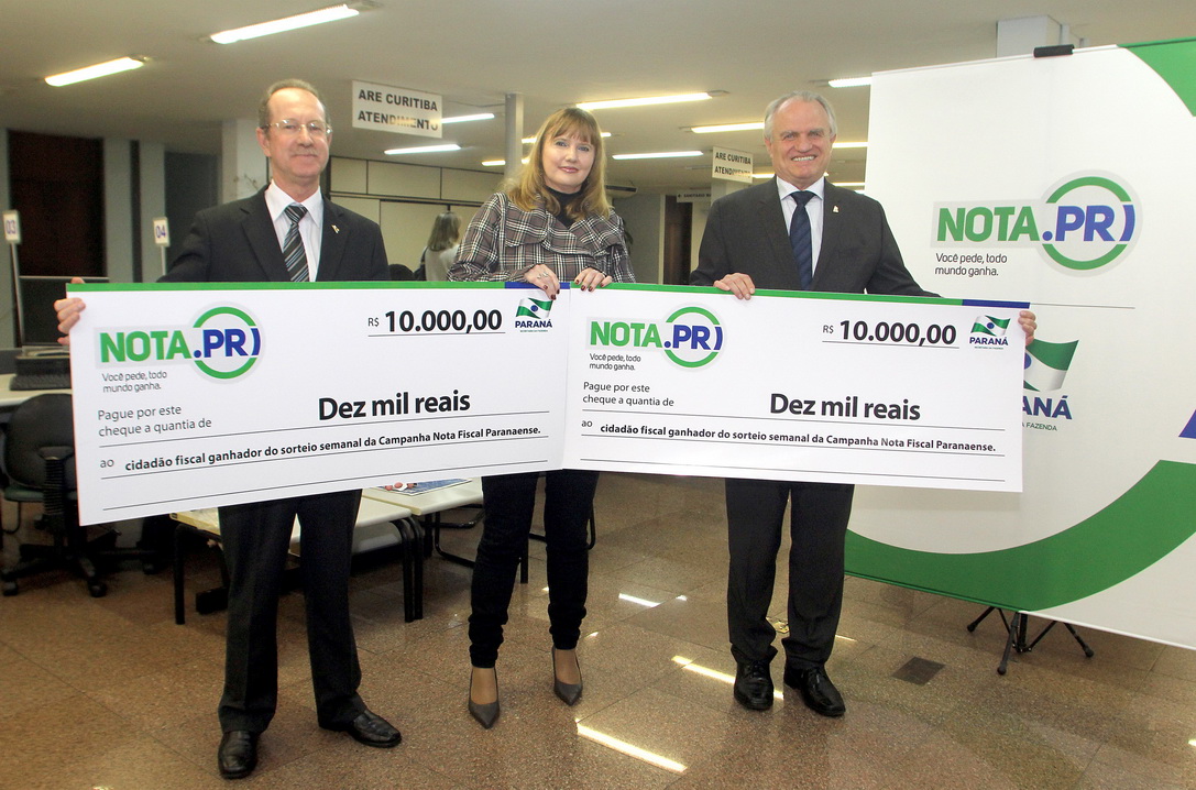 O psicólogo curitibano Marcio Simioni recebeu nesta quarta-feira (18) um cheque simbólico do primeiro prêmio mensal da campanha Nota Fiscal Paranaense, no valor de R$ 30 mil. Ele foi contemplado no sorteio realizado no dia 28 de maio. Outra premiada foi a professora Rosane Bihre Mattes, da rede municipal de ensino de Curitiba, que recebeu um cheque simbólico de R$ 20 mil, referente a um prêmio semanal acumulado.