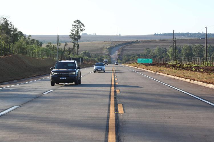 Rodovia asfaltada no Paraná com alguns veículos transitando
